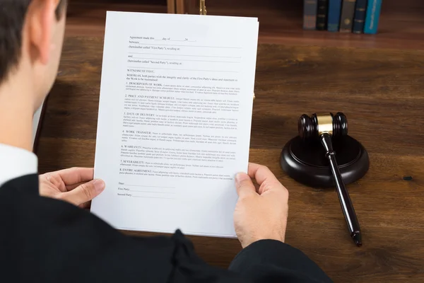 Juez leyendo documentos legales en el escritorio en la sala del tribunal — Foto de Stock