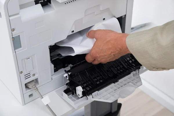 Удаление бумаги застрял в принтере — стоковое фото