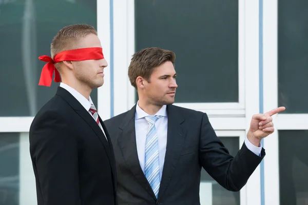 Businessman Assisting Blindfolded Partner — Stock Photo, Image