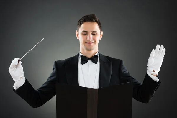 Glimlachend muziek dirigent houden Baton — Stockfoto
