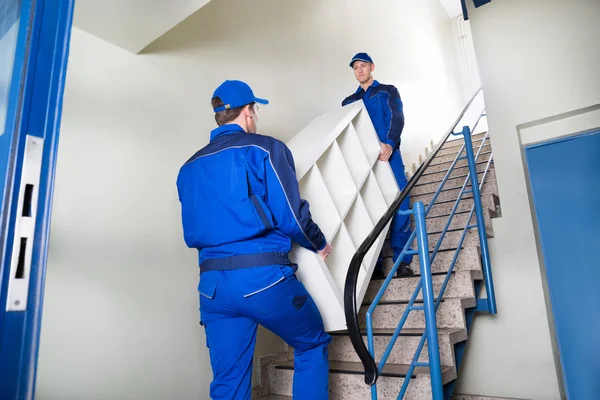 Beweger tragen Regal beim Treppensteigen — Stockfoto