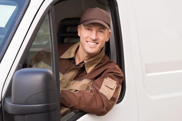 Fiducioso uomo di consegna sorridente nel camion — Foto Stock