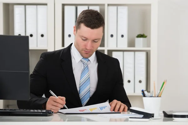 Geschäftsmann analysiert Finanztabellen — Stockfoto