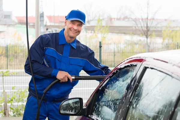 Homme travailleur lavage voiture rouge — Photo