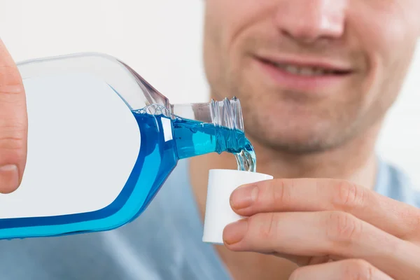 Gießen Flasche Mundwasser in Deckel — Stockfoto