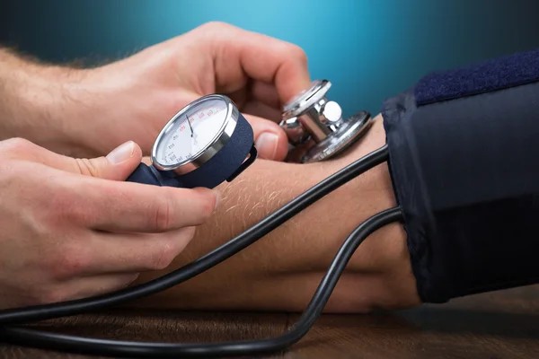 Lekarz sprawdzający ciśnienie krwi — Zdjęcie stockowe