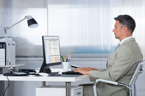 Mannelijke Accountant met behulp van Computer aan balie — Stockfoto