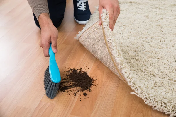 Hombre usando cepillo para barrer barro — Foto de Stock