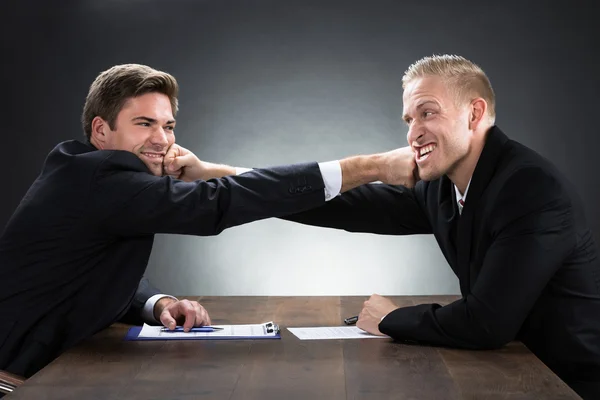 Young Businessmen Fighting At Wooden Desk — Stock Photo, Image