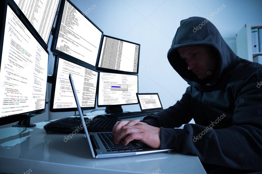 Hacker Using Laptop At Desk