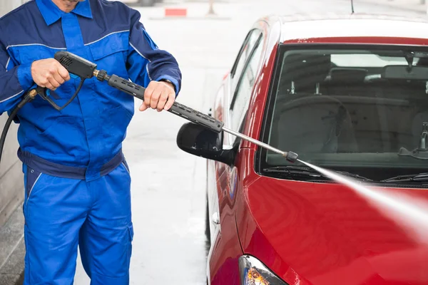 Arbeiter reinigt Auto mit Strahlspritze — Stockfoto