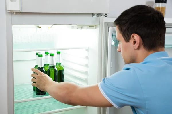 Extracción de la botella de cerveza del refrigerador — Foto de Stock