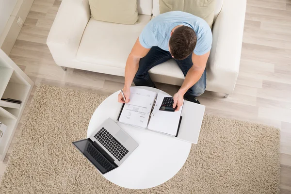 Hombre calculando las finanzas caseras en la tabla — Foto de Stock