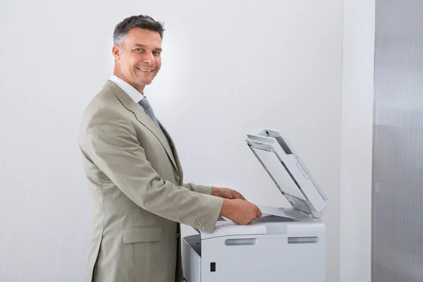 Empresario que guarda el papel en la fotocopiadora — Foto de Stock