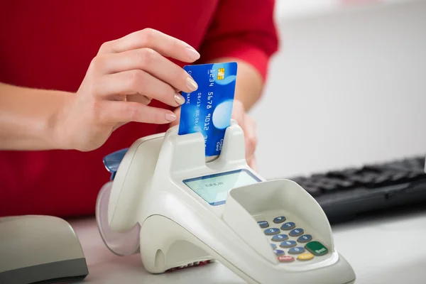 Vendedora deslizando tarjeta de crédito en el lector — Foto de Stock