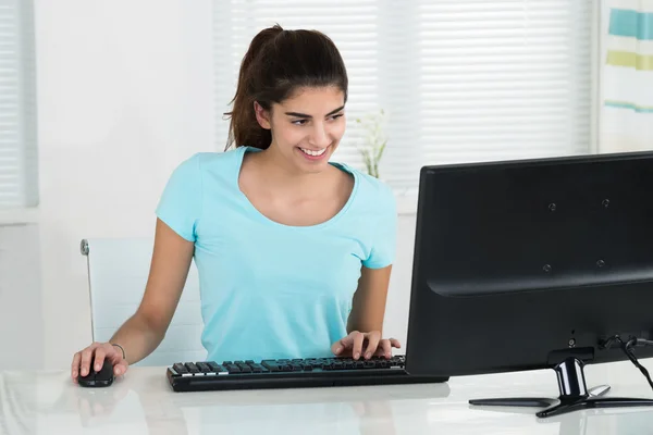 Estudante feminina usando computador na mesa — Fotografia de Stock