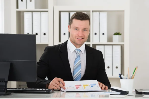 Empresário feliz analisando gráficos financeiros — Fotografia de Stock