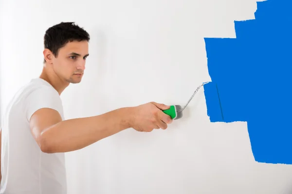 페인트 롤러로 벽을 페인팅하는 사람 — 스톡 사진