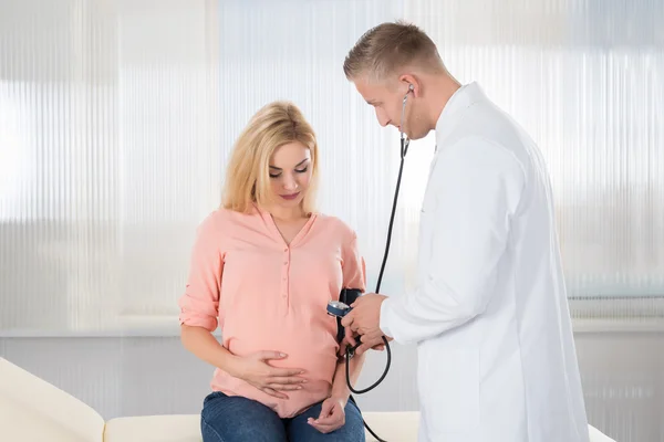 Médico verificando a pressão arterial — Fotografia de Stock