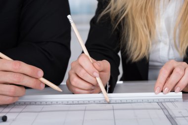 İş adamları bir mimari çizim tartışıyor