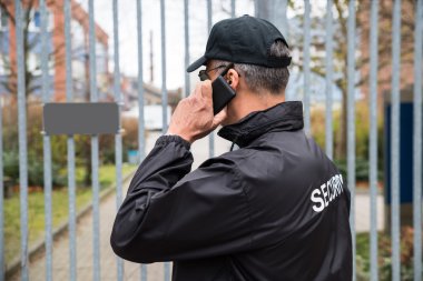 Güvenlik görevlisi cep telefonu üzerinde konuşurken
