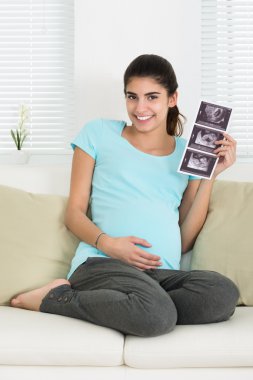 Ultrason kanepenin üzerinde tutan kadın