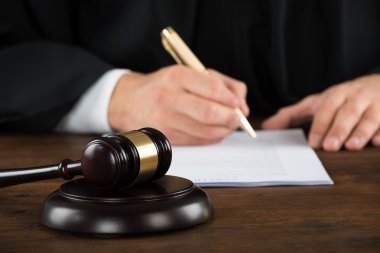 Yargıç yazma masasında yasal belgeler üzerinde