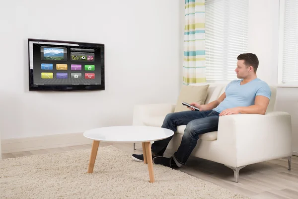 Чоловік дивиться телевізор вдома — стокове фото