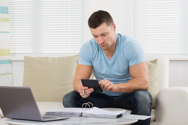 Homem calculando finanças domésticas na tabela — Fotografia de Stock