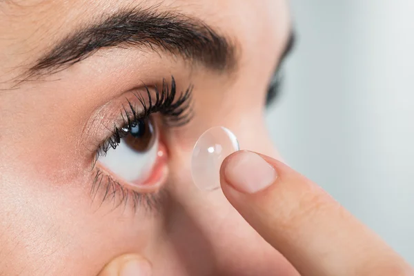 Mujer usando lentes de contacto en casa — Foto de Stock