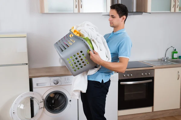 Hombre llevando pesada cesta de lavandería — Foto de Stock