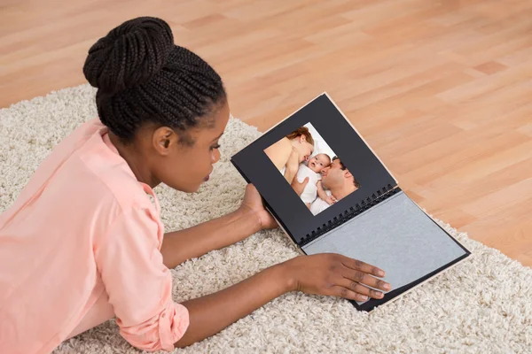 Vrouw op zoek naar fotoalbum — Stockfoto