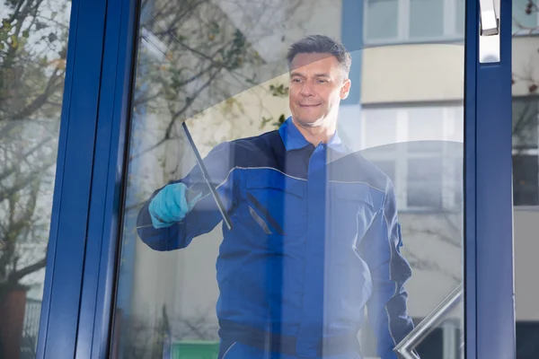 Mannelijke werknemer schoonmaken glas — Stockfoto