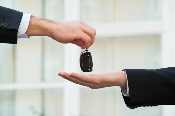 Autohändler übergibt Schlüssel an Geschäftsmann — Stockfoto