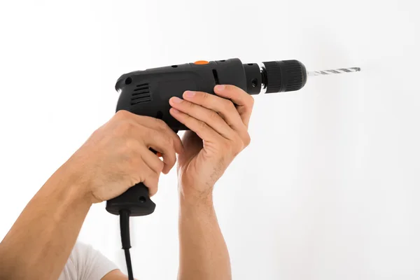 Hombre usando taladro de energía en la pared — Foto de Stock