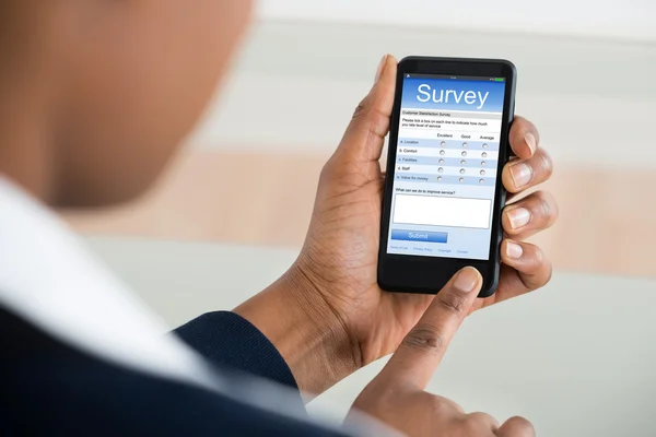 Geschäftsfrau füllt Fragebogen am Handy aus — Stockfoto