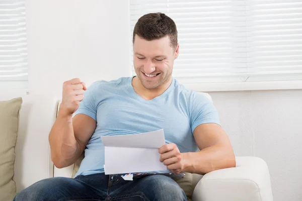 Hombre apretando el puño mientras lee la carta — Foto de Stock