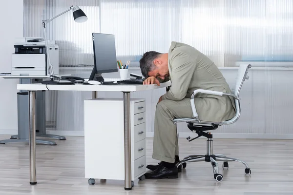 Uomo d'affari che dorme sulla scrivania in ufficio — Foto Stock