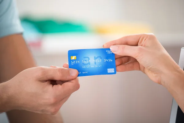 Vendedor tomando cartão de crédito do cliente — Fotografia de Stock