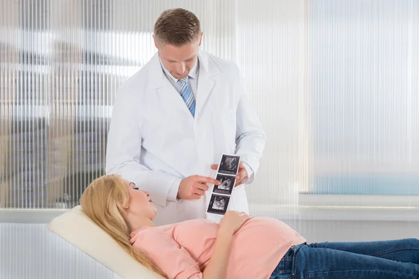 Молодой доктор показывает ультразвуковое сканирование — стоковое фото