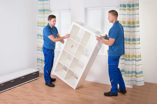 Movers Carrying Shelf At Home — Stock Photo, Image