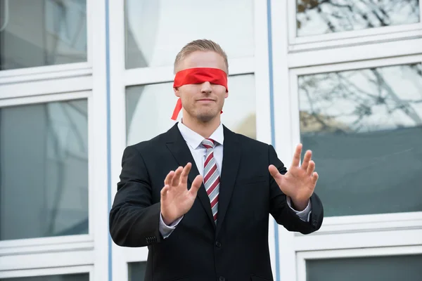 Бизнесмен с завязанными глазами стоит у окна — стоковое фото