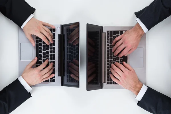 Empresarios que usan computadoras portátiles en la mesa en la oficina —  Fotos de Stock