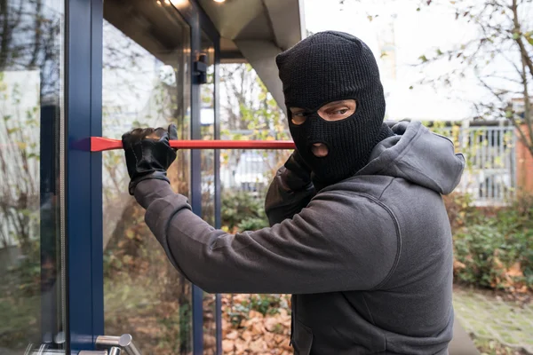 Met behulp van breekijzer om glazen deur te openen — Stockfoto