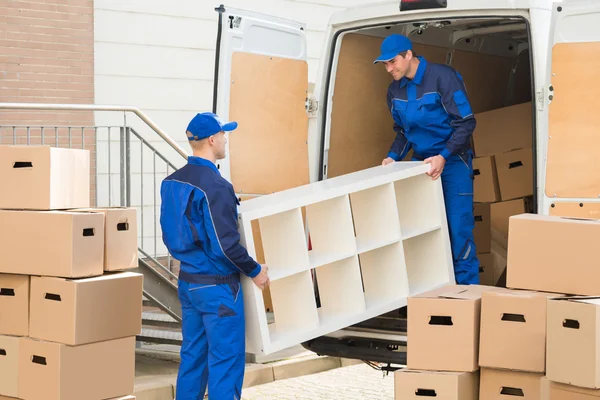 Umzugsunternehmen entladen Möbel aus LKW — Stockfoto