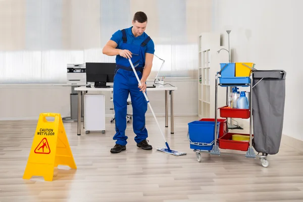 Καθαριστής σφουγγαρίζει πάτωμα στο γραφείο — Φωτογραφία Αρχείου