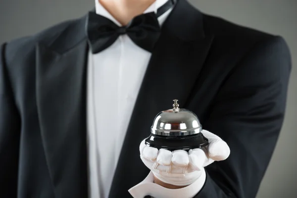 Midsection Of Waiter Holding Service Bell — Stock Photo, Image