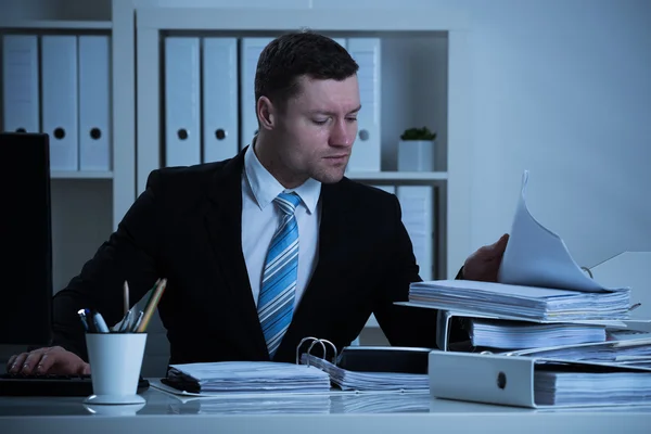 Affärsman jobbar sent i office — Stockfoto