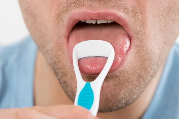 Hombre limpiando su lengua con raspador — Foto de Stock