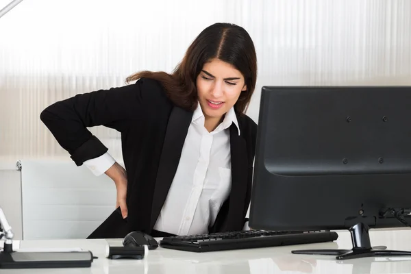 Mujer de negocios que sufre de dolor de espalda — Foto de Stock